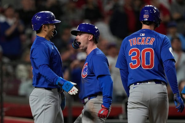 Chicago Cubs' Pete Crow-Armstrong, center, celebrates with Seiya Suzuki, left, and outfielder Kyle Tucker, right, after hitting a grand slam to right field during the seventh inning of a baseball game against the Cincinnati Reds, Friday, May 23, 2025, in Cincinnati. (AP Photo/Carolyn Kaster)