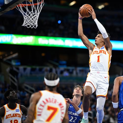 Atlanta Hawks forward Jalen Johnson (1) goes up to shoot between Orlando Magic forwards Franz Wagner (22) and Paolo Banchero (5) during the first half of an NBA basketball game, Friday, Oct. 24, 2025, in Orlando, Fla. (AP Photo/Phelan M. Ebenhack)