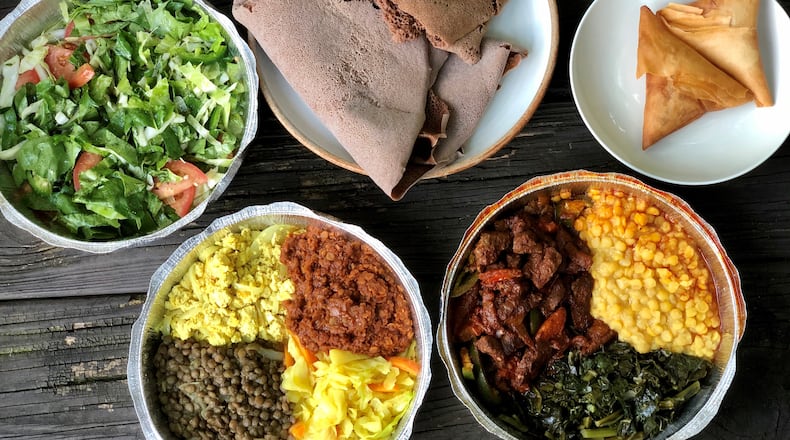 A takeout feast from Tigi’s Cafe & Food Truck in Stone Mountain: cabbage salad; teff injera; sambusas; beef tibs with collards and yellow split chickpeas; and a vegan sampler with tofu, split lentils in berbere sauce and brown lentils. CONTRIBUTED BY WENDELL BROCK