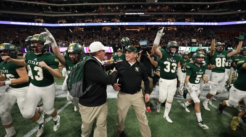 Blessed Trinity coach Tim McFarlin (center) celebrates with staff and players after their 23-9 win against Cartersville in the Class AAAA State Championship at Mercedes-Benz Stadium Wednesday, Dec. 12, 2018, in Atlanta. (Jason Getz/For the AJC)