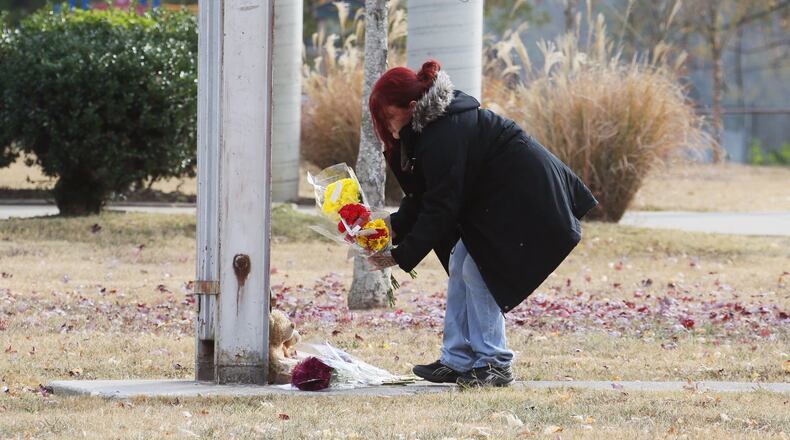 November 22, 2016 - Chattanooga - Michelle Hutto, who said her son was a friend of one of the victims and one of the injured, places flowers at Woodmore Elementary School. Two teddy bears were placed at the base of the school flag which stood at half mast. At least five children died days before Thanksgiving in a horrific crash in Chattanooga. Bus driver Johnthony Walker, 24, has been charged with five counts of vehicular homicide, reckless endangerment and reckless driving, the Chattanooga Police Department said. BOB ANDRES /BANDRES@AJC.COM