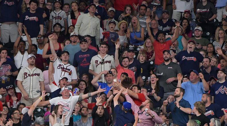 Fans try to catch a home-run ball at SunTrust Park. HYOSUB SHIN / HSHIN@AJC.COM