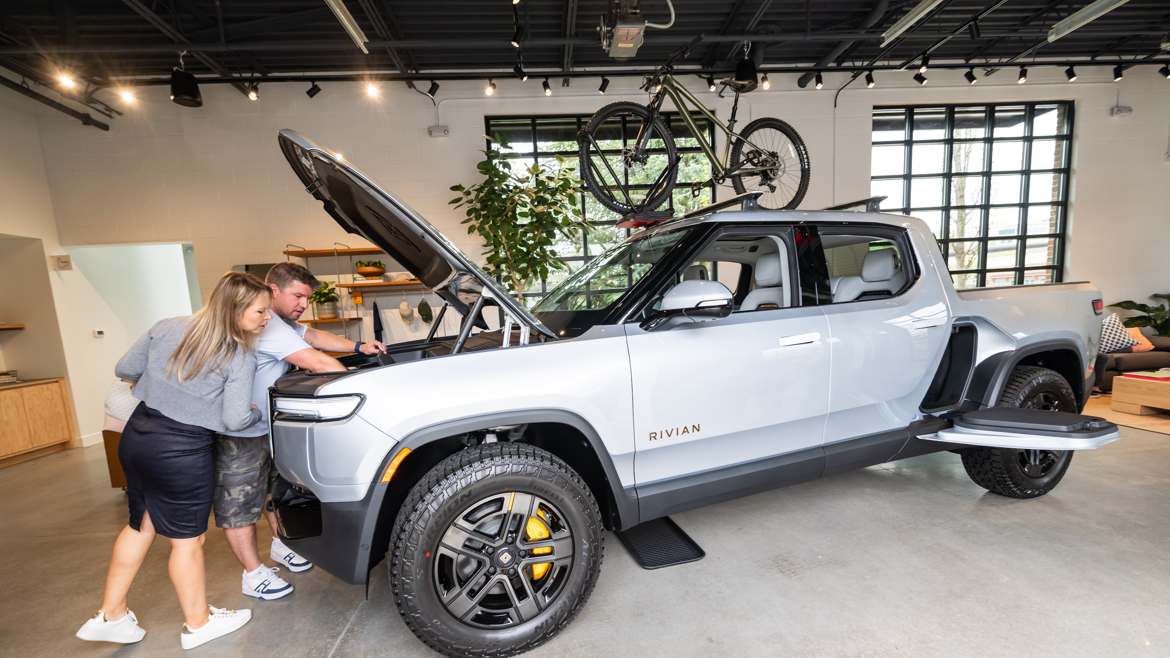 Christian and Katana Brunkow check out the front trunk of a Rivian R1T in the new Rivian “space” at Avalon in Alpharetta on Friday, April 4, 2025. (Bita Honarvar for the AJC)