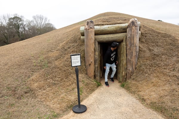 Chris Eaton exits a rebuilt earthen lodge at Ocmulgee Mounds National Historical Park in Macon on Friday, Jan. 23, 2026. It is the original site of a Native American tribal council chamber. (Arvin Temkar/AJC)