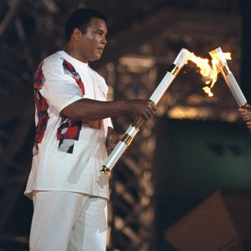 Muhammad Ali and USA swimming athlete Janet Evans carrying torch with flame at Centennial Olympic Stadium. Atlanta, Ga., July 19, 1996. (Courtesy of Lynn Johnson /Sports Illustrated)