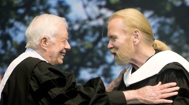Former President Jimmy Carter and Rock and Roll Hall of Famer Gregg Allman embrace while Allman receives an honorary Doctor of Humanities degree during Mercer University’s commencement at Hawkins Arena in Macon, Ga., on Saturday, May 14, 2016. (Jason Vorhees/The Macon Telegraph via AP) MANDATORY CREDIT