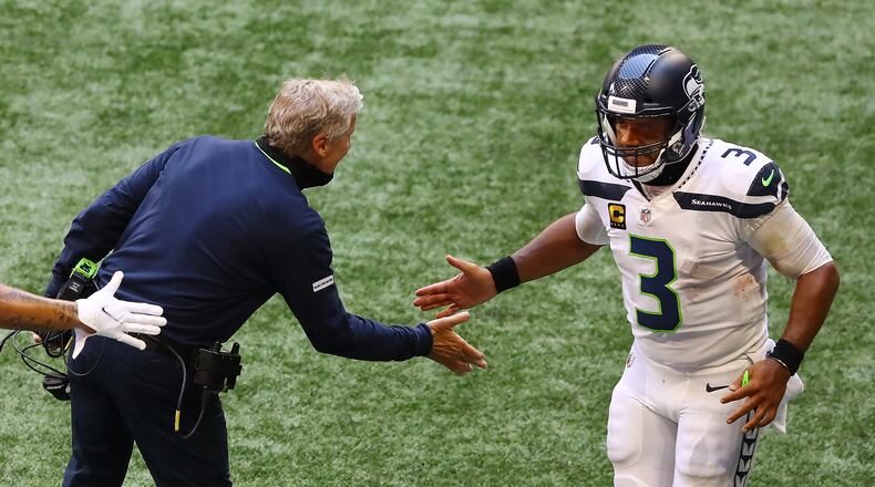 Seahawks quarterback Russell Wilson is greeted by head coach Pete Carroll on the sidelines during the third quarter Sunday, Sept. 13, 2020, at Mercedes-Benz Stadium in Atlanta. The NFL reminded coaches of face covering mandates on the field following Week 1 games.