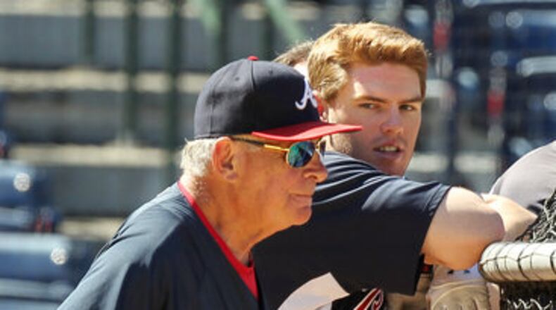 Bobby Cox and rookie Freddie Freeman take in batting practice. (AJC File)