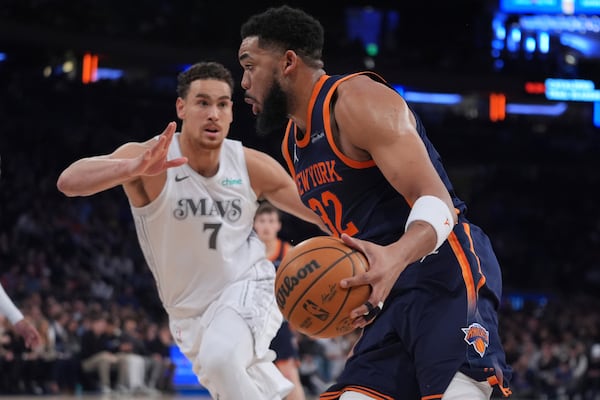 New York Knicks' Karl-Anthony Towns (32) drives past Dallas Mavericks' Dwight Powell (7) during the first half of an NBA basketball game Tuesday, March 25, 2025, in New York. (AP Photo/Frank Franklin II)