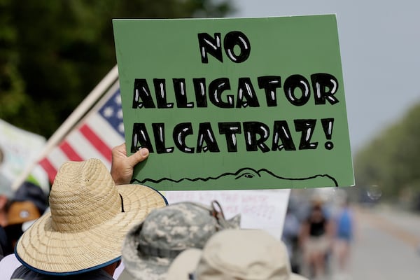 Environmental advocates and protesters at the Dade-Collier Training and Transition Airport on Tamiami Trail E, Ochopee, Fla., on Saturday, June 28, 2025, object to the "Alligator Alcatraz" being built at the facility. (Mike Stocker /South Florida Sun-Sentinel via AP)