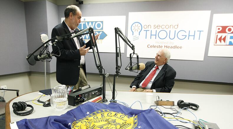 Former Gov. Roy Barnes, right, speaks to radio host Bill Nigut as they prepare for a discussion in 2015 about politics and the Confederate flag. In front of Barnes is the Georgia state flag from 2001 to 2003. Tami Chappell / Special to the AJC