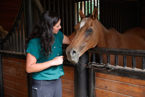 Joy Lim Nakrin plays with Bella, one of the rescue horses she cares for at Joyous Acres Farm in Milton on Thursday, July 17, 2025. (Natrice Miller/ AJC)