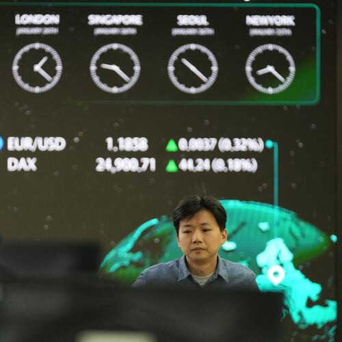 A dealer walks past near the screens showing the foreign exchange rates at a dealing room of Hana Bank in Seoul, South Korea, Monday, Jan. 26, 2026. (AP Photo/Lee Jin-man)