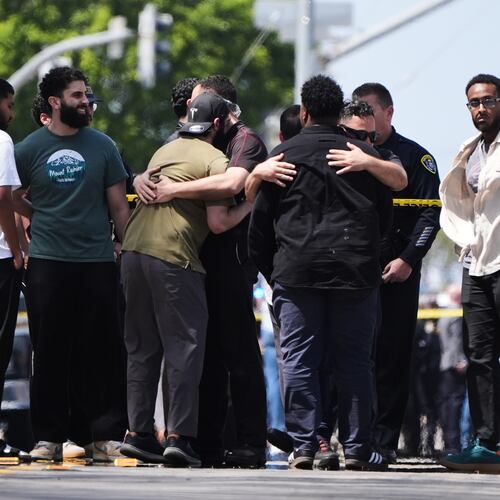 People embrace near the scene of a shooting outside the Islamic Center of San Diego Monday, May 18, 2026, in San Diego. (AP Photo/Gregory Bull)