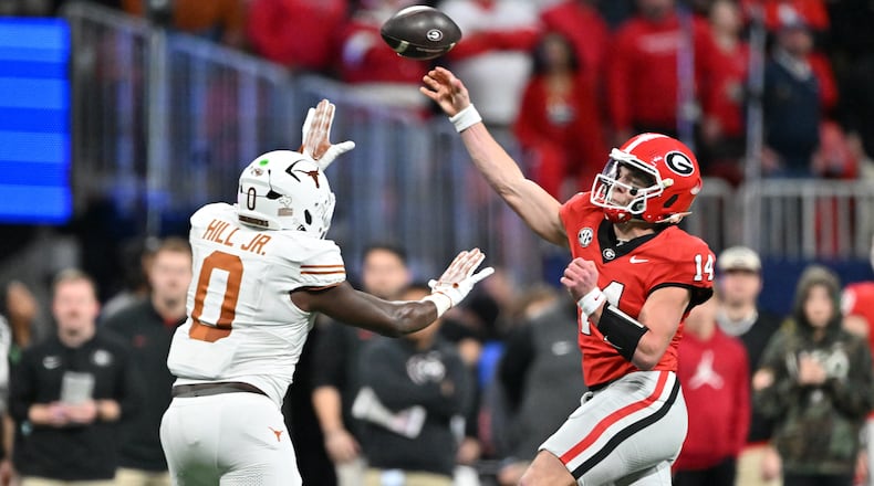 Georgia quarterback Gunner Stockton (14) throws a pass over Texas linebacker Anthony Hill Jr. (0) during the second half in the SEC Championship football game at the Mercedes-Benz Stadium, Saturday, December 7, 2024, in Atlanta. Georgia won 22-19 over Texas in overtime. (Hyosub Shin / AJC)