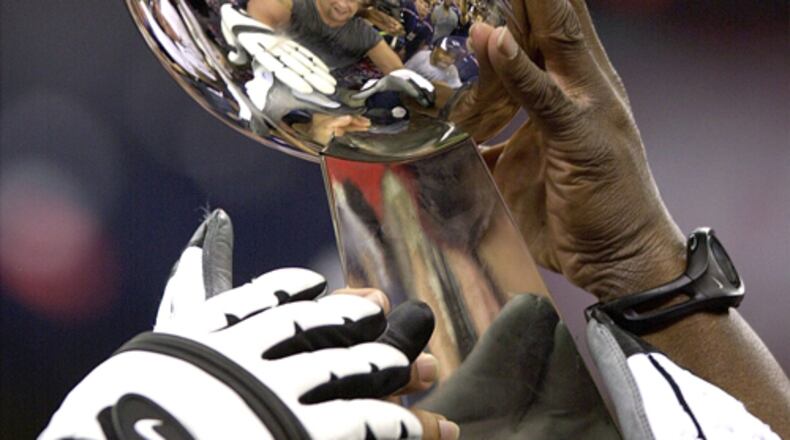 New England players hoist the Lombardi trophy after beating the St. Louis Rams 20-17 to win Super Bowl XXXVI at the Louisiana Superdome, in New Orleans, Louisiana, on Sunday, Feb. 3, 2002.