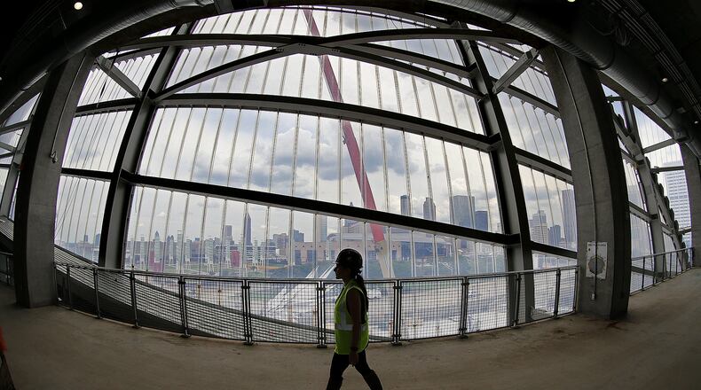 A worker passes by the “window to the city” in Mercedes-Benz Stadium, which will host college football’s national championship game Jan. 8. Curtis Compton/ccompton@ajc.com