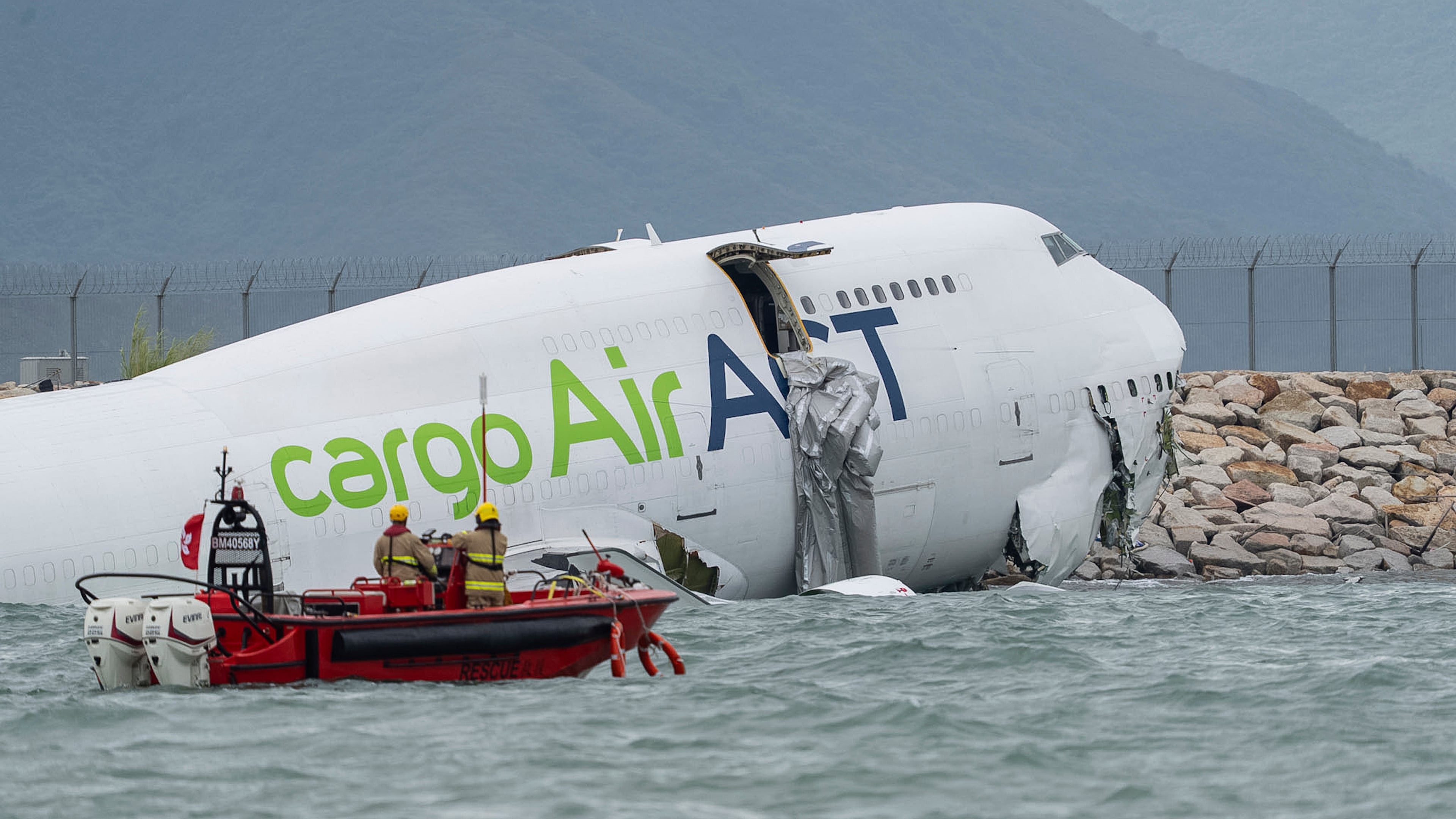 Rescue workers approach a cargo aircraft that skidded off a Hong Kong runway on Monday, Oct. 20, 2025. (AP Photo/Chan Long Hei)