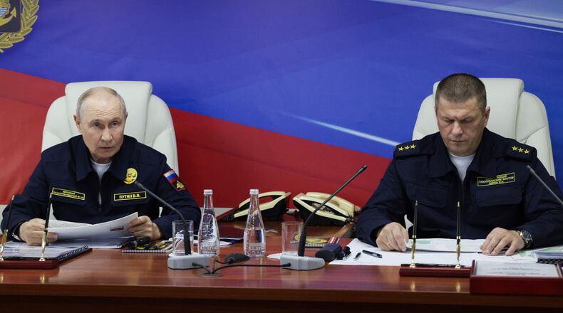 Russian President Vladimir Putin, left, and Russian Pacific Fleet Commander-in-Chief Admiral Viktor Liina attends a meeting with navy officers on board of the Varyag missile cruiser of the Pacific Fleet during a military exercise near Yuzhno-Sakhalinsk, on Sakhalin Island, Russia, Wednesday, Aug. 12, 2026. (Gavriil Grigorov, Sputnik, Kremlin Pool Photo via AP)