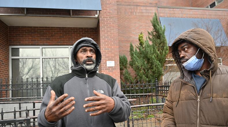 Michael Smith (left) shares his story as Mackendy Pierrette looks outside the Gateway Center in Atlanta on Thursday, January 20, 2022. The Gateway Center is a homeless service center. (Hyosub Shin / Hyosub.Shin@ajc.com)