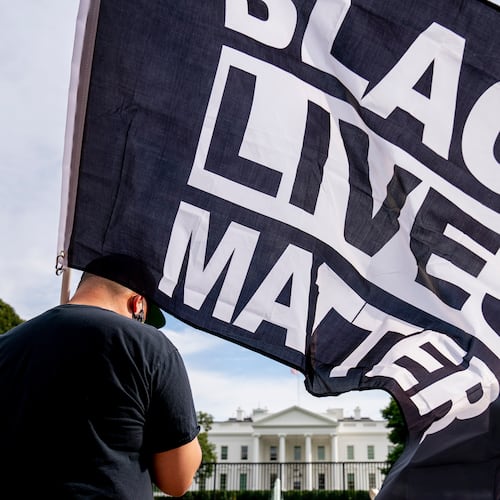 FILE - A man carries a Black Lives Matter flag in Lafayette Square outside the White House on the fourth night of the Republican National Convention, Aug. 27, 2020, in Washington. (AP Photo/Andrew Harnik, File)
