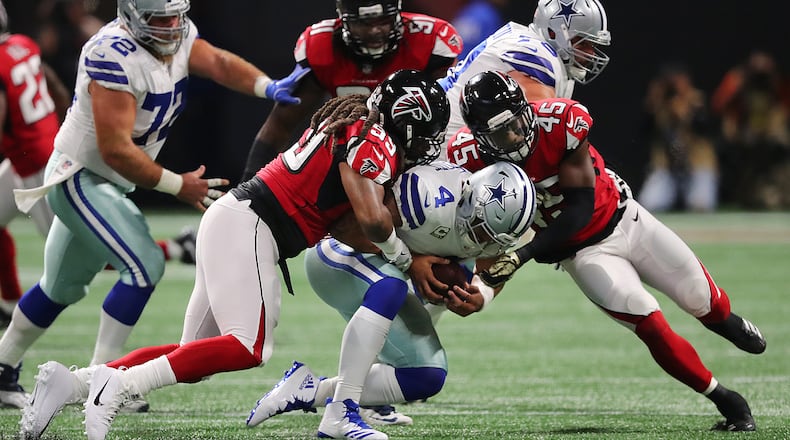 Falcons defensive end Adrian Clayborn (99) and linebacker Deion Jones (45) sack Dallas quarterback Dak Prescott in the first quarter on last Sunday’s game.