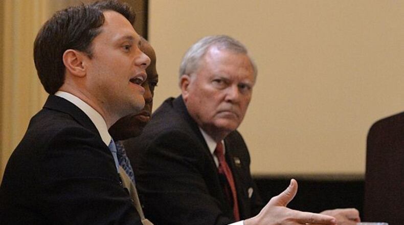 Gov. Nathan Deal shoots a glance at Democrat Jason Carter during a Monday event hosted by the Professional Association of Georgia Educators. Kent D. Johnson, kdjohnson@ajc.com