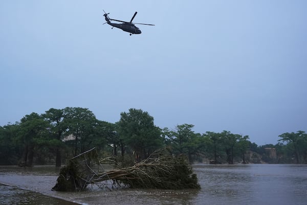 A helicopter flies over the Guadalupe River after a flash flood swept through the area, Friday, July 4, 2025, in Kerrville, Texas. (AP Photo/Eric Gay)