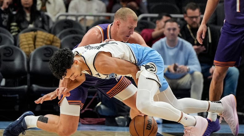 Phoenix Suns center Mason Plumlee (22) and Atlanta Hawks forward Zaccharie Risacher (10) vie for a loose ball during the first half of an NBA basketball game, Tuesday, Jan. 14, 2025, in Atlanta. (AP Photo/Mike Stewart)