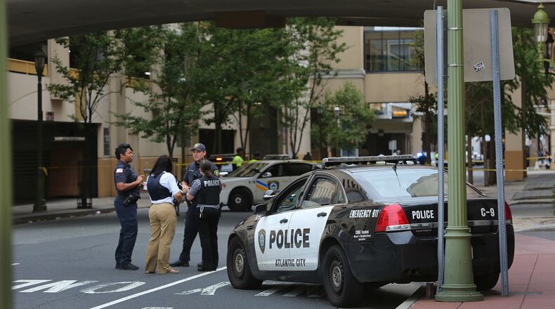 Police investigate at the scene of a shooting on Saturday, Sept. 3, 2016 in Atlantic City, N.J. Authorities say a New Jersey police officer remains in critical condition after he was shot during an exchange of gunfire outside an Atlantic City casino. Acting Atlantic County Prosecutor Diane Ruberton said that the officer underwent surgery Saturday morning after the shooting that left one suspect dead. (Ben Fogletto /The Press of Atlantic City via AP)