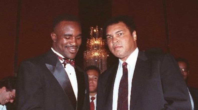 Muhammad Ali retired from boxing in 1981. A decade later, he greeted then-heavyweight champion Evander Holyfield of Atlanta during an awards dinner in New York. (AJC file photo)