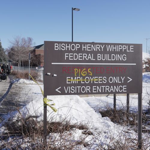 FILE - Protesters yell at cars coming and going near a defaced sign for Bishop Whipple Federal building in Minneapolis on Wednesday, Jan. 28, 2026. (AP Photo/Laura Bargfeld, File)