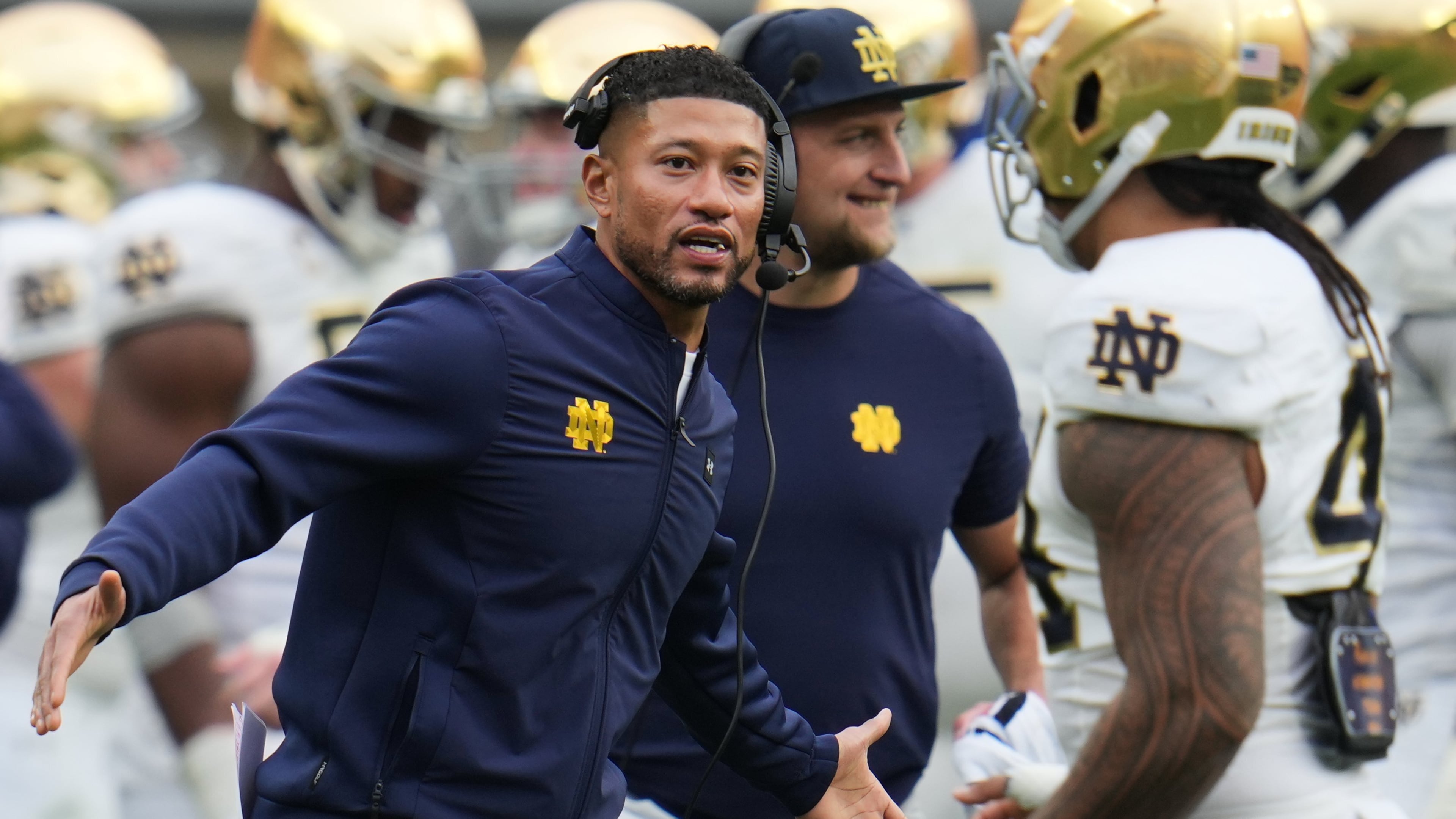 Notre Dame head coach Marcus Freeman, left, greets players as they return to the sideline during the second half of an NCAA college football game against Pittsburgh in Pittsburgh, Saturday, Nov. 15, 2025. (AP Photo/Gene J. Puskar)