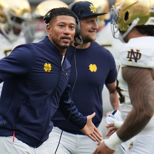Notre Dame head coach Marcus Freeman, left, greets players as they return to the sideline during the second half of an NCAA college football game against Pittsburgh in Pittsburgh, Saturday, Nov. 15, 2025. (AP Photo/Gene J. Puskar)