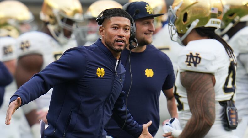 Notre Dame head coach Marcus Freeman, left, greets players as they return to the sideline during the second half of an NCAA college football game against Pittsburgh in Pittsburgh, Saturday, Nov. 15, 2025. (AP Photo/Gene J. Puskar)
