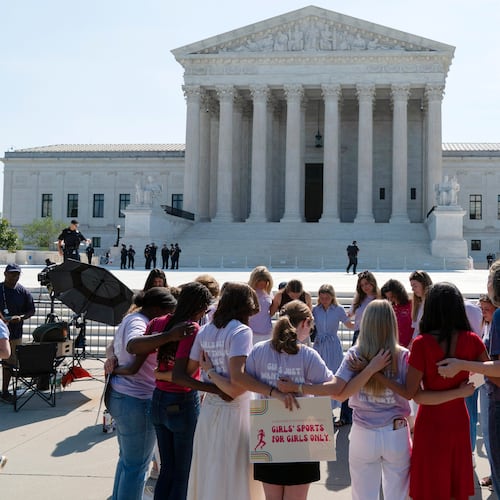 A group prays outside of the Supreme Court ahead of the court's ruling on whether transgender girls and women can play on school athletic teams, Tuesday, June 30, 2026, on Capitol Hill in Washington. (AP Photo/Jose Luis Magana)