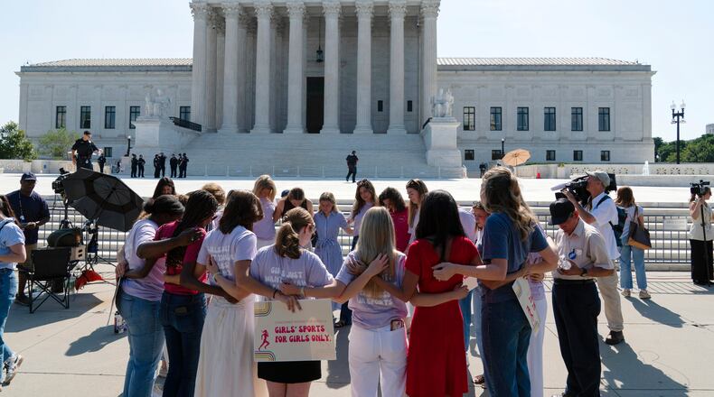 A group prays outside of the Supreme Court ahead of the court's ruling on whether transgender girls and women can play on school athletic teams, Tuesday, June 30, 2026, on Capitol Hill in Washington. (AP Photo/Jose Luis Magana)