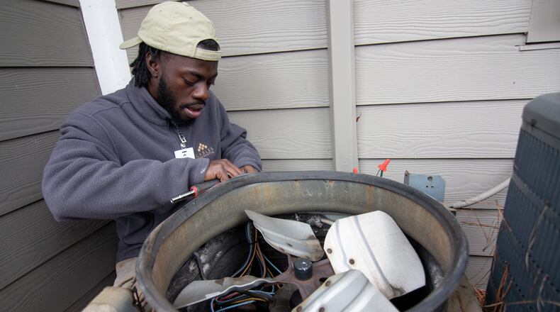 Moma Sayplay works on repairing a heat pump at the Gables Mills Apartments Monday, February 10, 2020. STEVE SCHAEFER / SPECIAL TO THE AJC