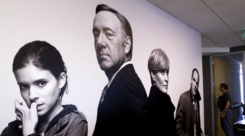 At Netflix headquarters in Los Gatos, Calif., in July 2014: an employee stands in a hallway near a large photo montage of characters from Netflix’ “House of Cards.” (Paul Sakuma Photography/provided by Netflix)