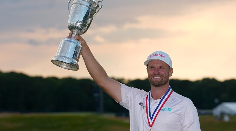 Wyndham Clark holds the trophy after winning the U.S. Open golf tournament at Shinnecock Hills Golf Club in Southampton, N.Y., Sunday, June 21, 2026. (AP Photo/Gerald Herbert)