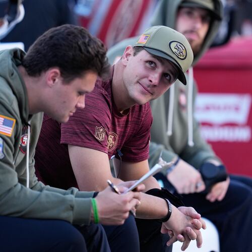Injured San Francisco 49ers quarterback Brock Purdy, middle, sits on the bench during the first half of an NFL football game against the Los Angeles Rams in Santa Clara, Calif., Sunday, Nov. 9, 2025. (AP Photo/Godofredo A. Vásquez)