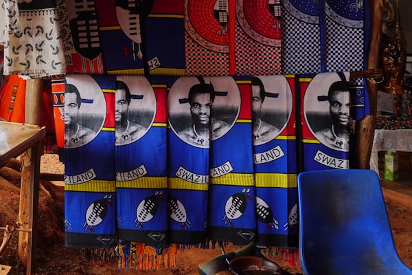 Cloths with King Mswati III's image sit for sale at a market in Lobamba, Eswatini, Friday, Aug. 17, 2018. (AP Photo/Jon Orbach)