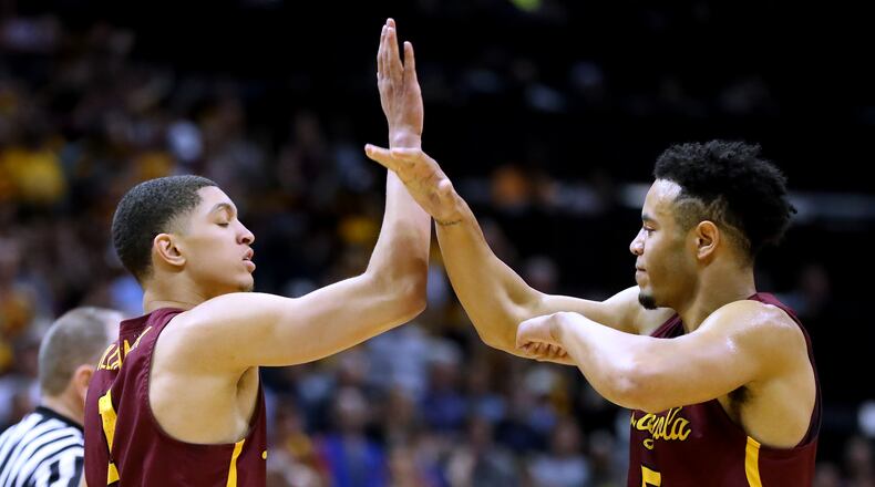 Loyola guard Lucas Williamson (left) gets five from Marques Townes after sinking a basket and drawing a foul against Kansas State during the first half in a regional final NCAA college basketball game on Saturday.