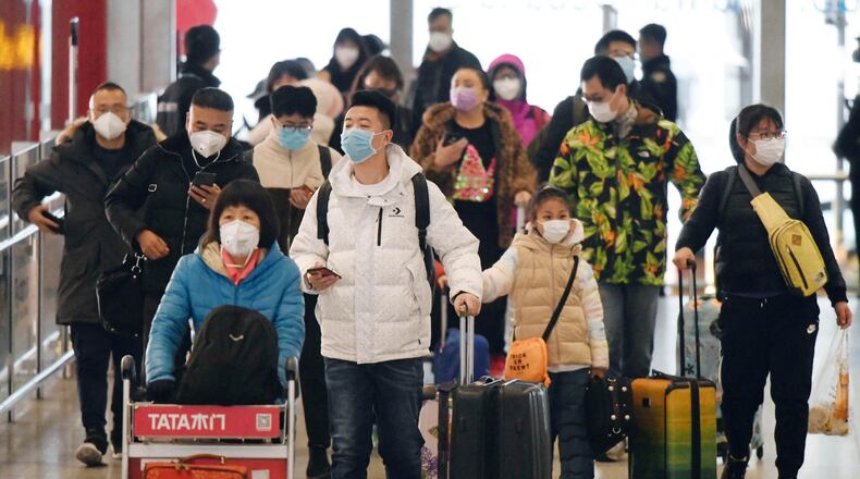 Passengers wear masks at Beijing international airport on Jan. 24, 2020, the first day of the Lunar New Year holiday, amid the spread of pneumonia caused by a new coronavirus believed to have originated in the central Chinese city of Wuhan. (Kyodo via AP Images) ==Kyodo