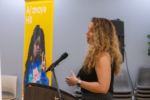 Douglas County District Attorney Dalia Racine speaks at an event following the unveiling of state road signs dedicated in honor of Aj’anaye Hill and Samuel Micah Moon. (Arvin Temkar / AJC)