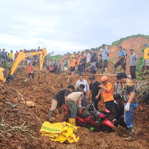 In this photo released on Saturday, Nov. 29, 2025 by the Indonesian National Search and Rescue Agency (BASARNAS), rescuers remove a scooter buried in the mud as they search for victims at a village hit by a landslide in Batu Goading, North Sumatra, Indonesia. (BASARNAS via AP)