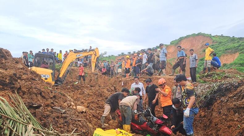 In this photo released on Saturday, Nov. 29, 2025 by the Indonesian National Search and Rescue Agency (BASARNAS), rescuers remove a scooter buried in the mud as they search for victims at a village hit by a landslide in Batu Goading, North Sumatra, Indonesia. (BASARNAS via AP)