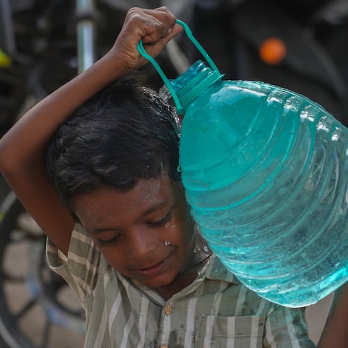 A boy carries a water can which he collect from a public tap in Mumbai, India, Saturday, June 20, 2026. (AP Photo/Rafiq Maqbool)