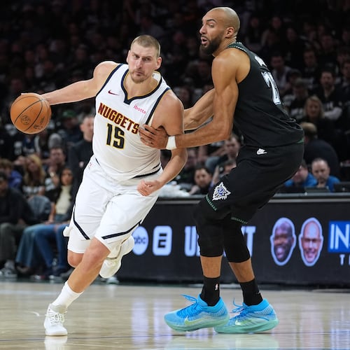 Denver Nuggets center Nikola Jokic (15) works toward the basket as Minnesota Timberwolves center Rudy Gobert, right, defends during the first half of Game 4 of a first-round NBA basketball playoff series, Saturday, April 25, 2026, in Minneapolis. (AP Photo/Abbie Parr)
