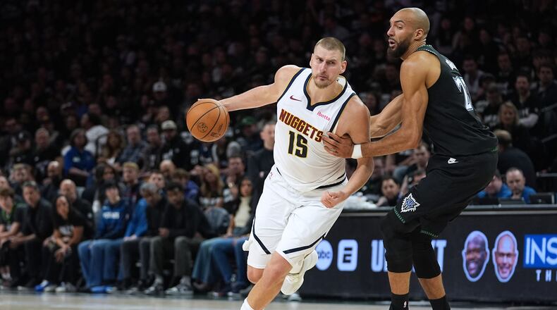 Denver Nuggets center Nikola Jokic (15) works toward the basket as Minnesota Timberwolves center Rudy Gobert, right, defends during the first half of Game 4 of a first-round NBA basketball playoff series, Saturday, April 25, 2026, in Minneapolis. (AP Photo/Abbie Parr)